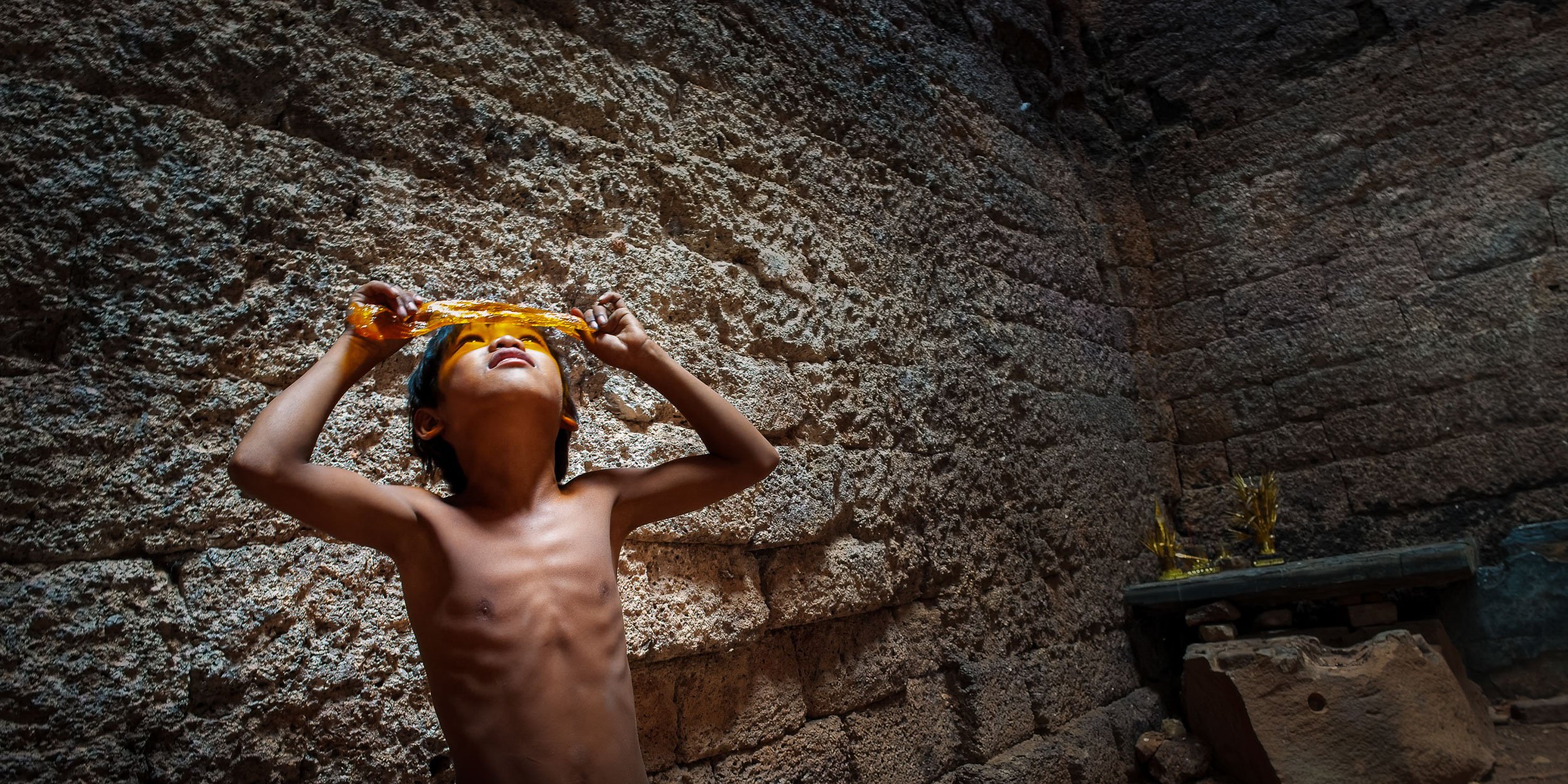 Boy-looks-at-sun-through-Angkor-temple-roof-Cambodia